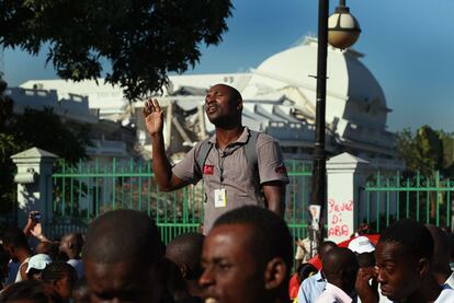 Un hombre reza delante de los restos del palacio presidencial de Puerto Príncipe. Un año después de la catástrofe, el país más pobre de América es un enorme campamento de chabolas.