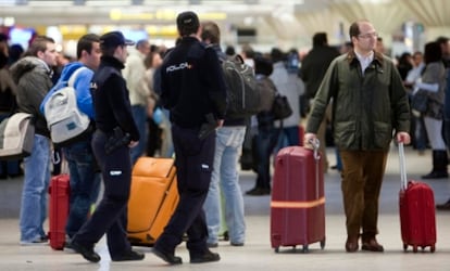 Una pareja de policías vigila la zona de facturación del aeropuerto de Sevilla durante el paro de los controladores.