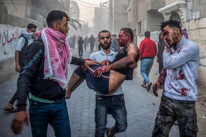 Un hombre traslada a un herido en Rafah, tras un bombardeo israelí, este jueves.