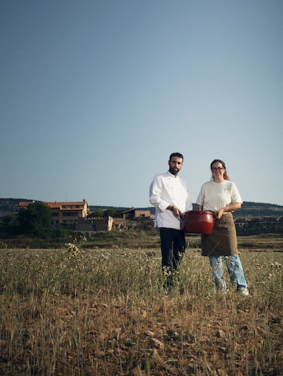 El cocinero Alberto Montañés y la jefa de sala María Dávila de Exite (Teruel), posan con una olla de la abuela de Montañés frente al hotel Mas de Cebrián (Puertomingalvo, Teruel) donde se encuentra su restaurante.