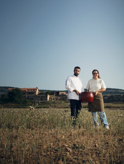 El cocinero Alberto Montañés y la jefa de sala María Dávila de Exite (Teruel), posan con una olla de la abuela de Montañés frente al hotel Mas de Cebrián (Puertomingalvo, Teruel) donde se encuentra su restaurante. 