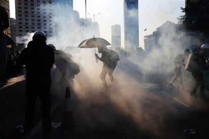 Un manifestante se protege con un paraguas de los gases lacrimógenos lanzados por la policía en Hong Kong.