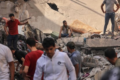 Un hombre se sienta entre los escombros de un edificio alcanzado por un misil israelí, mientras los palestinos buscan supervivientes en Jan Yunis, al sur de la franja de Gaza.