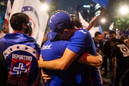 Dos seguidores del Cruz Azul celebran la victoria del equipo, en el Ángel de la Independencia, en Ciudad de México, este domingo.