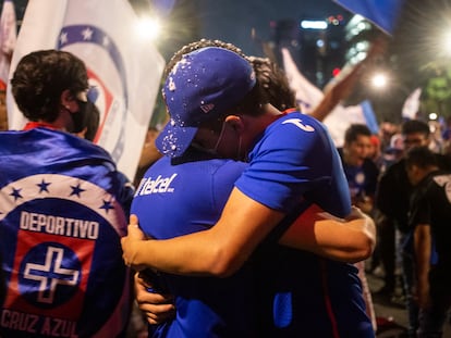 Dos seguidores del Cruz Azul celebran la victoria del equipo, en el Ángel de la Independencia, en Ciudad de México, este domingo.