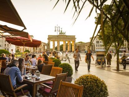 Una cafetería en Unter den Linden con la Puerta de Brandenburg al fondo.