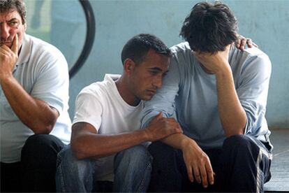 El padre del bebé (a la derecha) era ayer consolado por familiares y vecinos a las puertas del hospital.