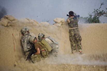 Un soldado afgano dispara un lanzagranadas mientras tres soldados estadounidenses se resguardan, ayer en la provincia de Kandahar.