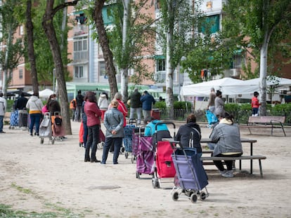 Vecinos a la espera de que les entreguen alimentos en la Asociación de Vecinos de Aluche, este sábado.