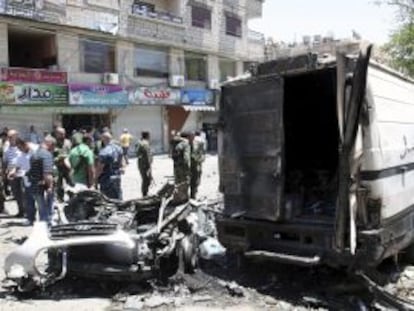 Oficiales de seguridad inspeccionan la zona del atentado del viernes en Qadesiya, Damasco
