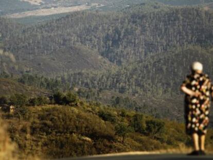 Una mujer observa los montes de Berrocal y Riotinto afectados por el incendio.