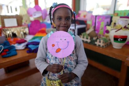 Una niña sostiene una pancarta en la que se puede leer " Yo lucho contra el cáncer con mi sonrisa" durante una campaña de donación para pacientes con cáncer en un colegio en Bengasi (Libia), el 11 de febrero de 2017.