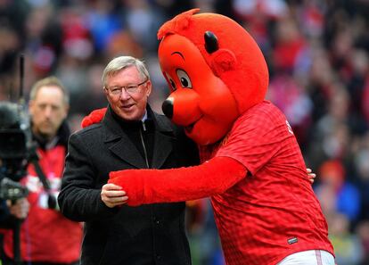 Ferguson se abraza con la mascota del Manchester United.