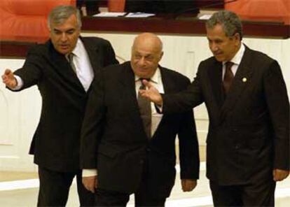 El presidente del Parlamento turco, Bulent Arinc (derecha), invita al presidente turcochipriota, Rauf Denktash (centro), a colocarse en la tribuna desde la que el mandatario se dirigió ayer a la Cámara.