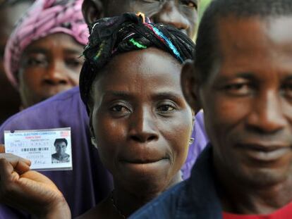 Una mujer sostiene su carn&eacute; para votar en Liberia.