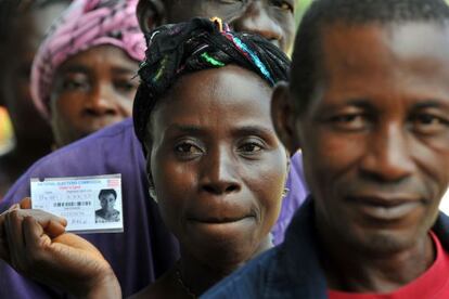 Una mujer sostiene su carn&eacute; para votar en Liberia.