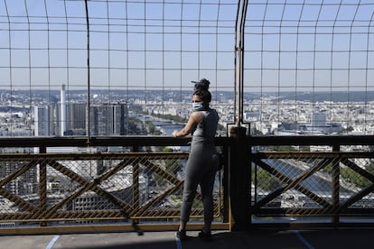 El uso de mascarilla es obligatorio a partir de los 11 años y hay un número de visitantes limitado tanto en su explanada como en sus plantas, En la imagen, una visitante en la Torre Eiffel.