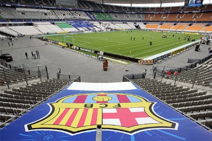 Una lona con el escudo del Barça preside los últimos preparativos del estadio de Saint-Denis.