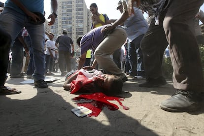 El cadáver de un simpatizantes del presidente depuesto Mohamed Mursi yace en el suelo tras ser alcanzado por un disparo del Ejército egipcio durante una manifestación frente a la sede de la Guardia Republicana en El Cairo (Egipto), 5 de julio de 2013. 