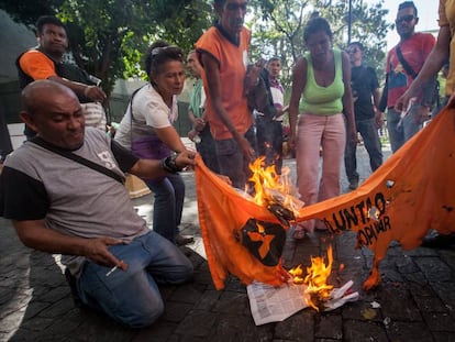 Chavistas queimam bandeira de partido opositor na Venezuela.