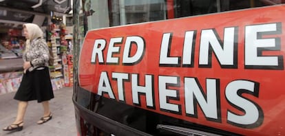 Una mujer camina junto a un autob&uacute;s tur&iacute;stico en Atenas, Grecia. 