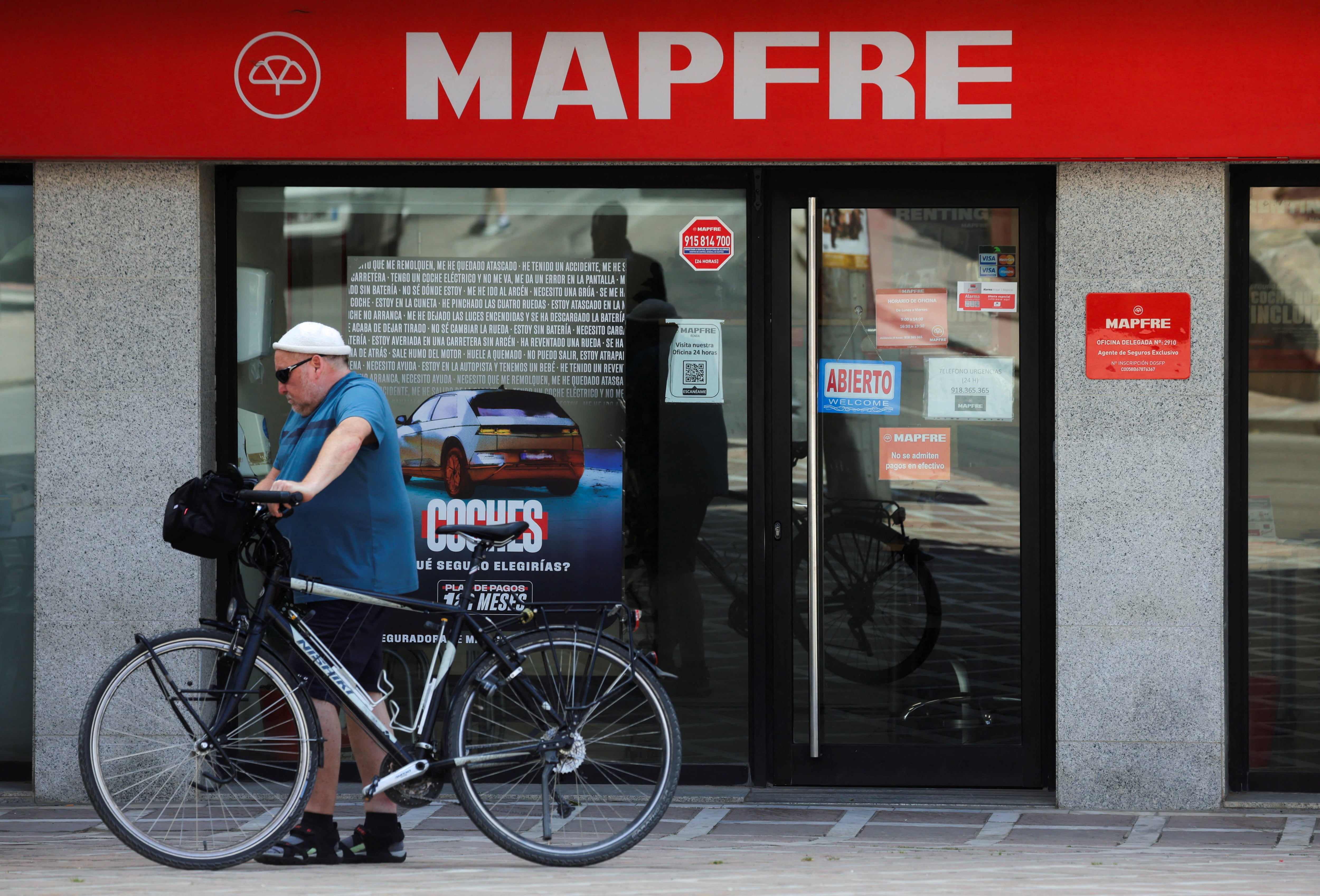 Una persona pasa delante de una sucursal de Mapfre, en Ronda.