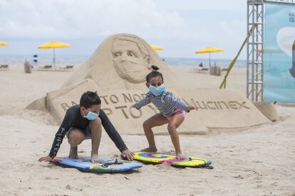 Dos niños juegan a surfear en una playa de Florida (EE UU).