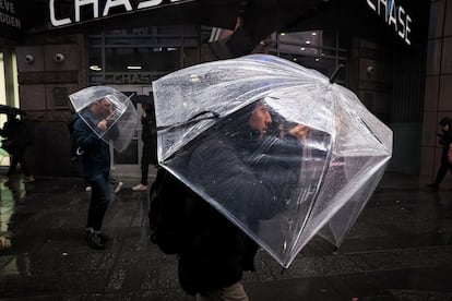 People walk through wind and rain during a nor'easter storm in Times Square in New York City, on April 3, 2024.