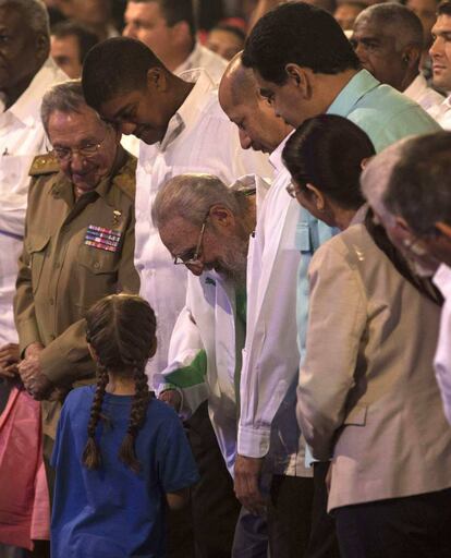 Fidel Castro recibe los presentes de una niña durante el homenaje por su 90 cumpleaños