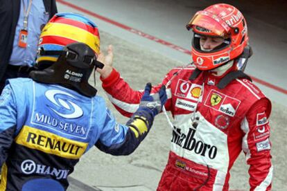 Fernando Alonso y Michael Schumacher se saludan al trmino de su duelo.