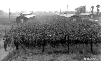 Prisioneros de guerra alemanes capturados tras el desembarco de Normandía son vigilados por tropas estadounidenses en el campamento de Nonant-le-Pin, Francia, el 21 de agosto de 1944.