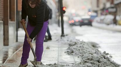 La localidad vasca, una de las más castigadas por el temporal, recupera poco a poco la normalidad. En la imagen, una mujer retira la nieve de la acera en una calle del centro de la ciudad.