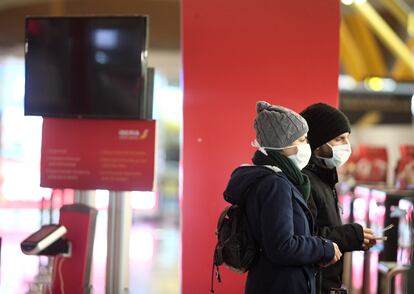 Dos pasajeros protegidos con mascarilla, este jueves en la Terminal 4 del Aeropuerto de Madrid.