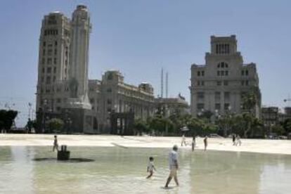 Varios turistas se refrescan en el lago de la Plaza de España de las altas temperaturas que se registran en el Archipiélago canario. EFE/Archivo