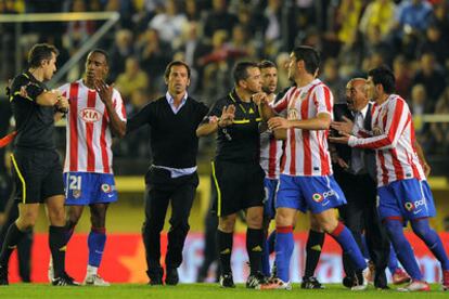 Los jugadores del Atlético, con Quique, que fue expulsado, en medio, reclaman al árbitro un penalti de Gonzalo a Agüero.