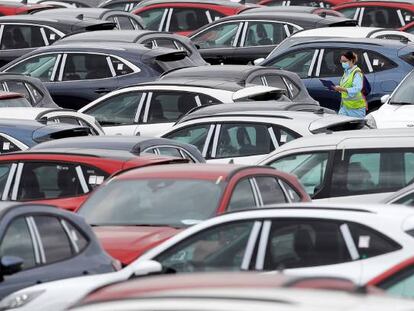 Una trabajadora de Ford camina entre automóviles aparcados en el exterior de la planta en Almussafes (Valencia). 