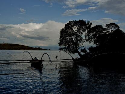 Un niño se balancea en las pértigas de un pesquero amarrado en una cala del lago Kivu.