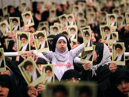 Mujeres iraníes, y entre ellas una niña, sostienen retratos del ayatolá Ali Jamenei durante una reunión en Teherán.