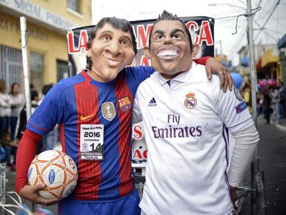 Dos hombres disfrazados de Messi y de Ronaldo. 