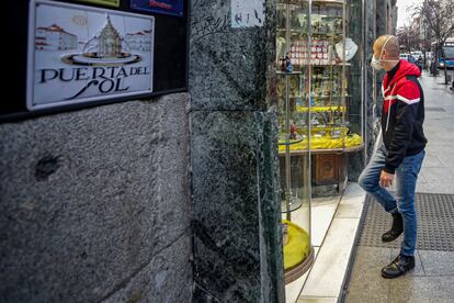 Un hombre entra en una tienda del centro de Madrid con mascarilla.