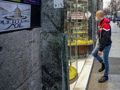 Un hombre entra en una tienda del centro de Madrid con mascarilla.