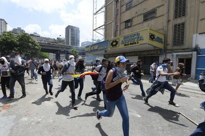 Activistas de la oposición corren durante la protesta organizada contra el gobierno de Nicolás Maduro, en Caracas.