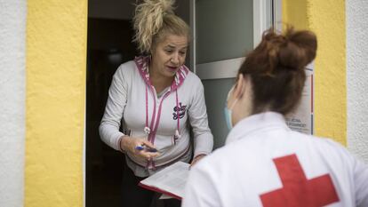 Cristina, voluntària de Creu Roja, porta menjar a Yoslen Garrido, al barrio de Nou Barris. 
