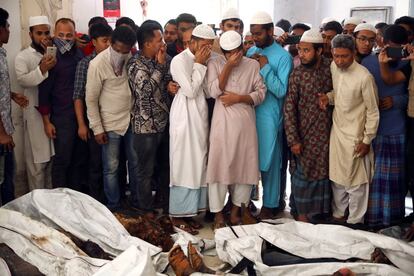 Al menos 70 personas han muerto y 10 se encuentran en estado crítico en un gigantesco incendio que afectó a varios edificios en el popular mercado de Chawkbazar, en la parte antigua de la capital de Bangladés, Dacca. En la imagen, familiares de las víctimas intentan identificar los cuerpos.