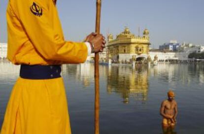 Un peregrino se baña en el estaque que rodea el templo dorado de Amritsar, santuario sagrado para los sijs.