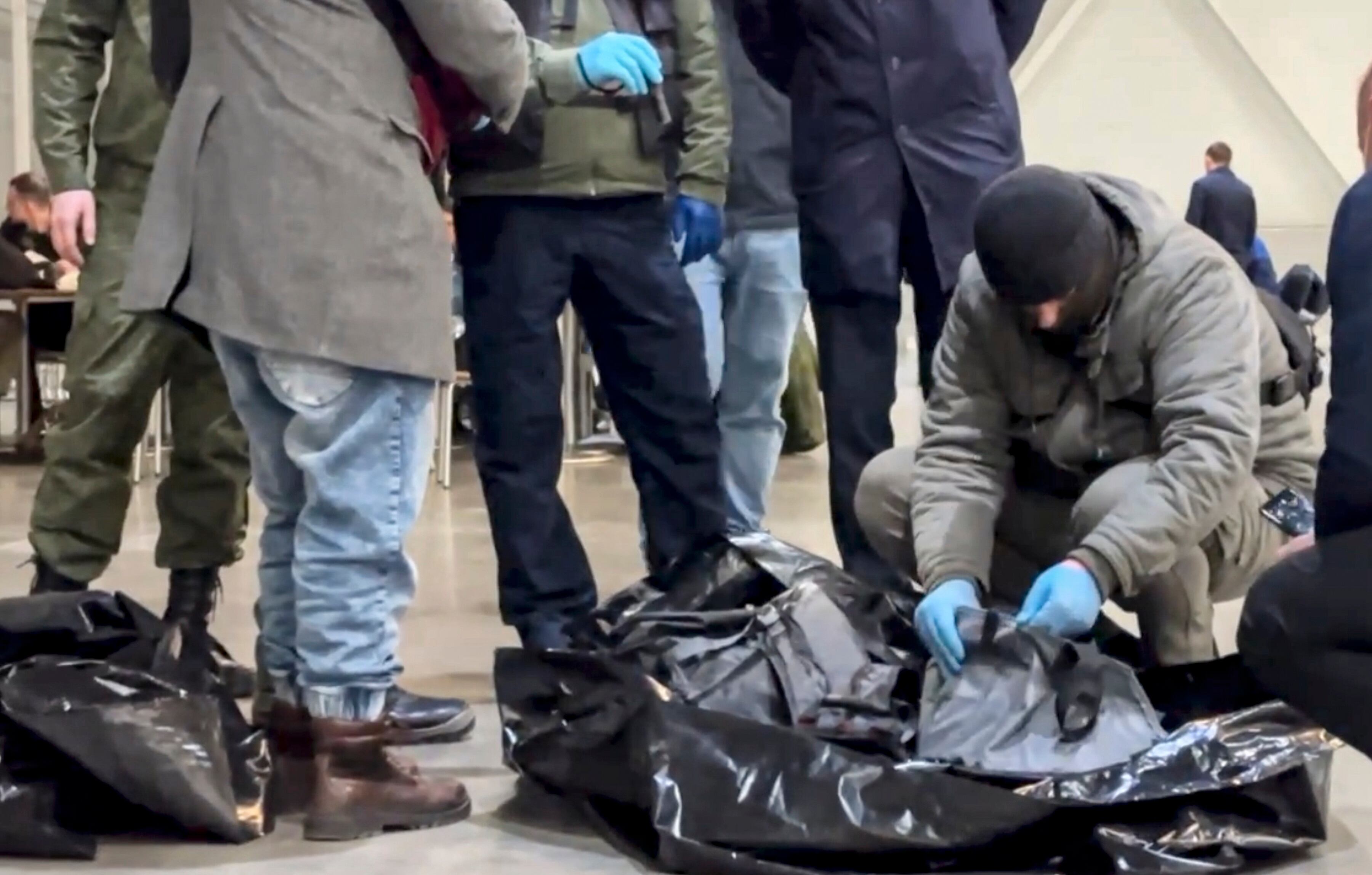 Agentes investigan junto a los restos de armamento encontrados en el centro comercial tras el ataque. 