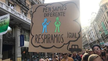 Sign reads: “We think differently, we breathe the same.”