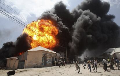 Un grupo de personas huyen durante la explosión de un almacén de gasolina cerca de un mercado en Bakara (Somalia).