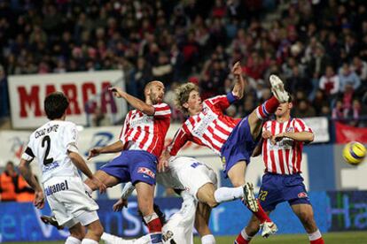 Fernando Torres intenta rematar de espaldas ante la mirada de Colsa y Montiel.