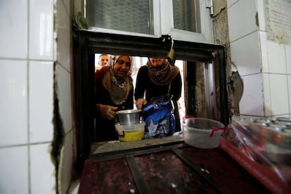 Mujeres reciben comida para personas necesitadas durante el mes del Ramadán en una mezquita suní de Irak, el 14 de junio de 2016.